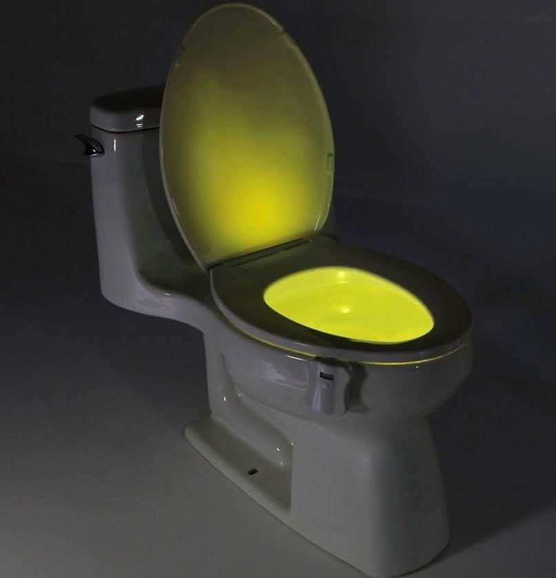 Toilet LED light attachment with yellow glowing oval on the seat