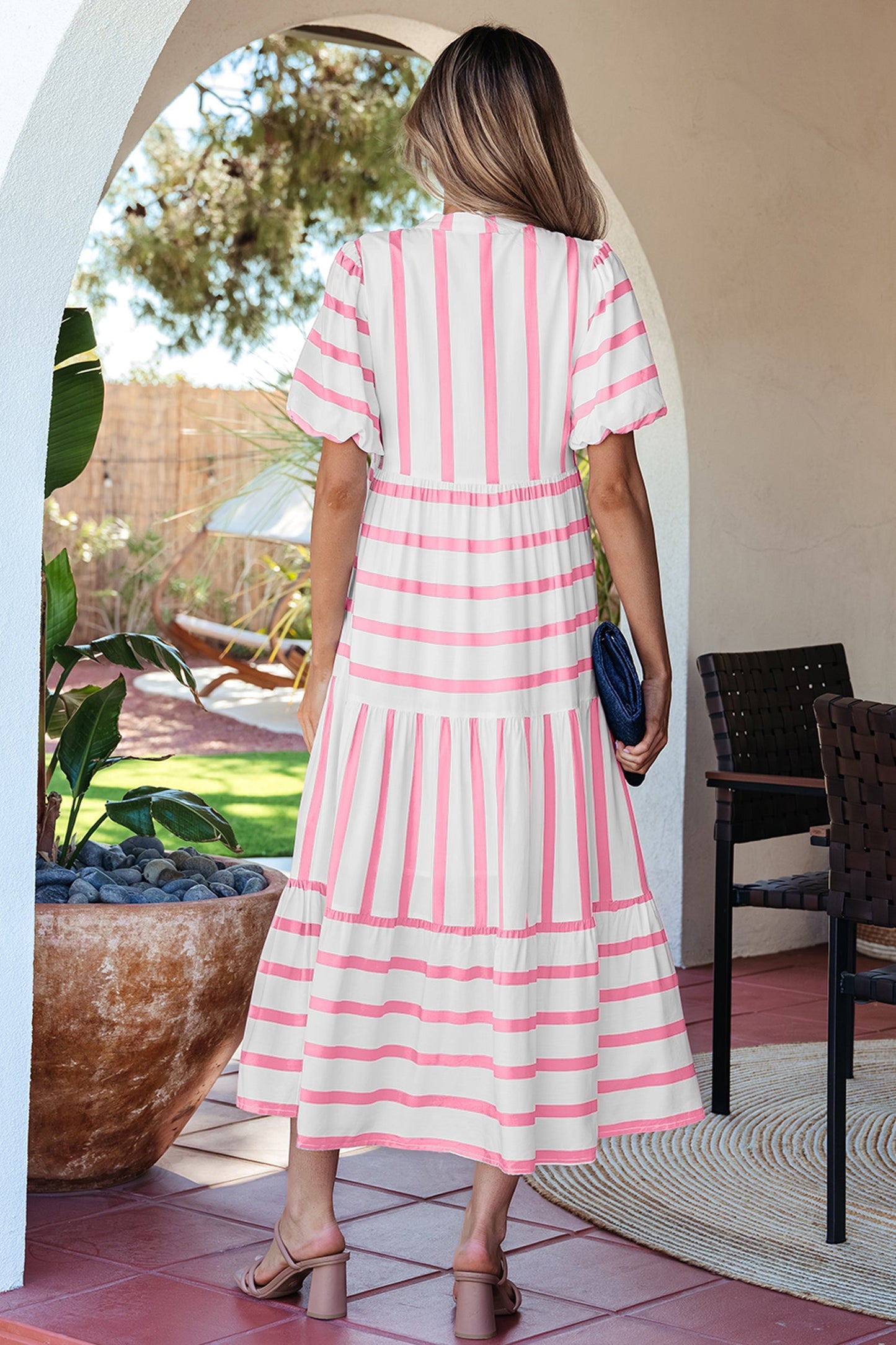 Pink striped half-sleeve tiered vacation dress, back view with flowing ruffled skirt
