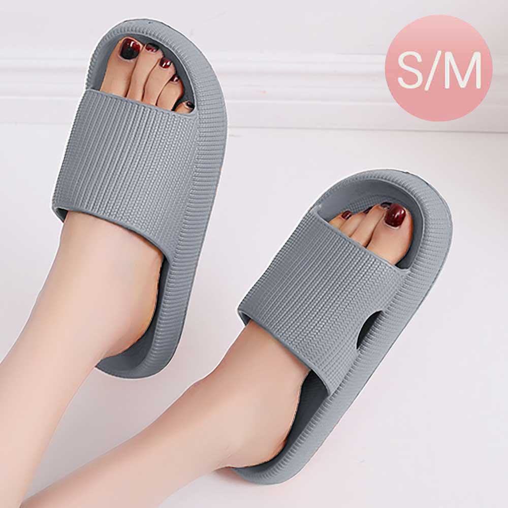 Gray slide sandals with wide strap, worn by feet with open-toe design