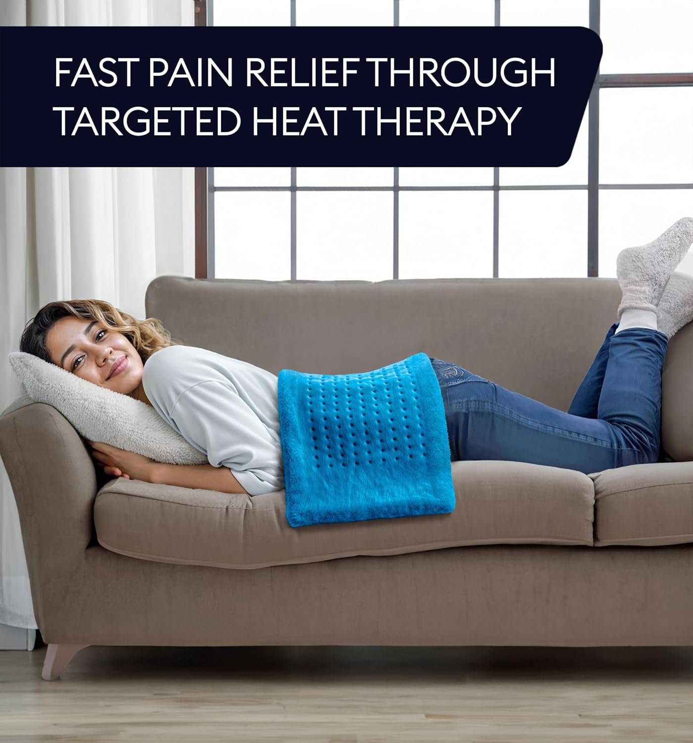 Aqua blue heating pad resting on a couch, connected to the power cord