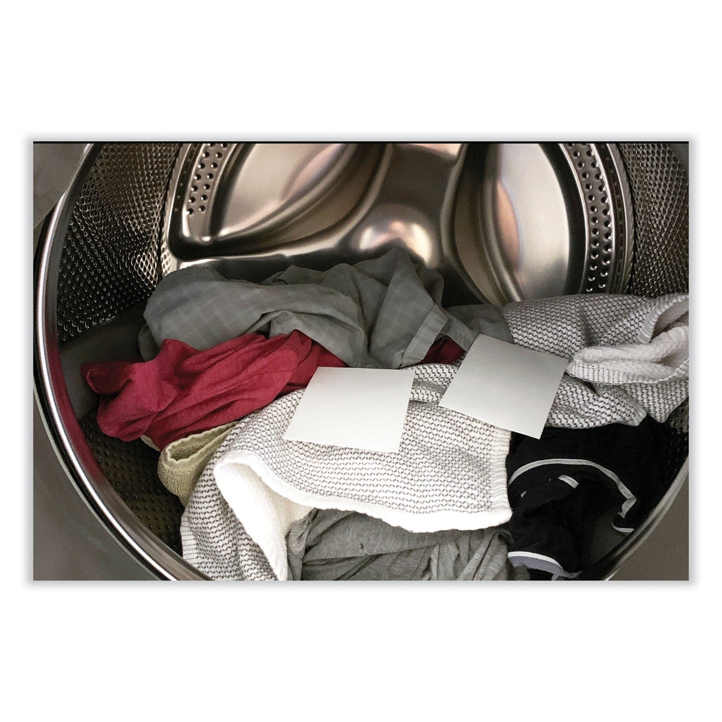 Laundry detergent sheets in a washer drum with folded clothes