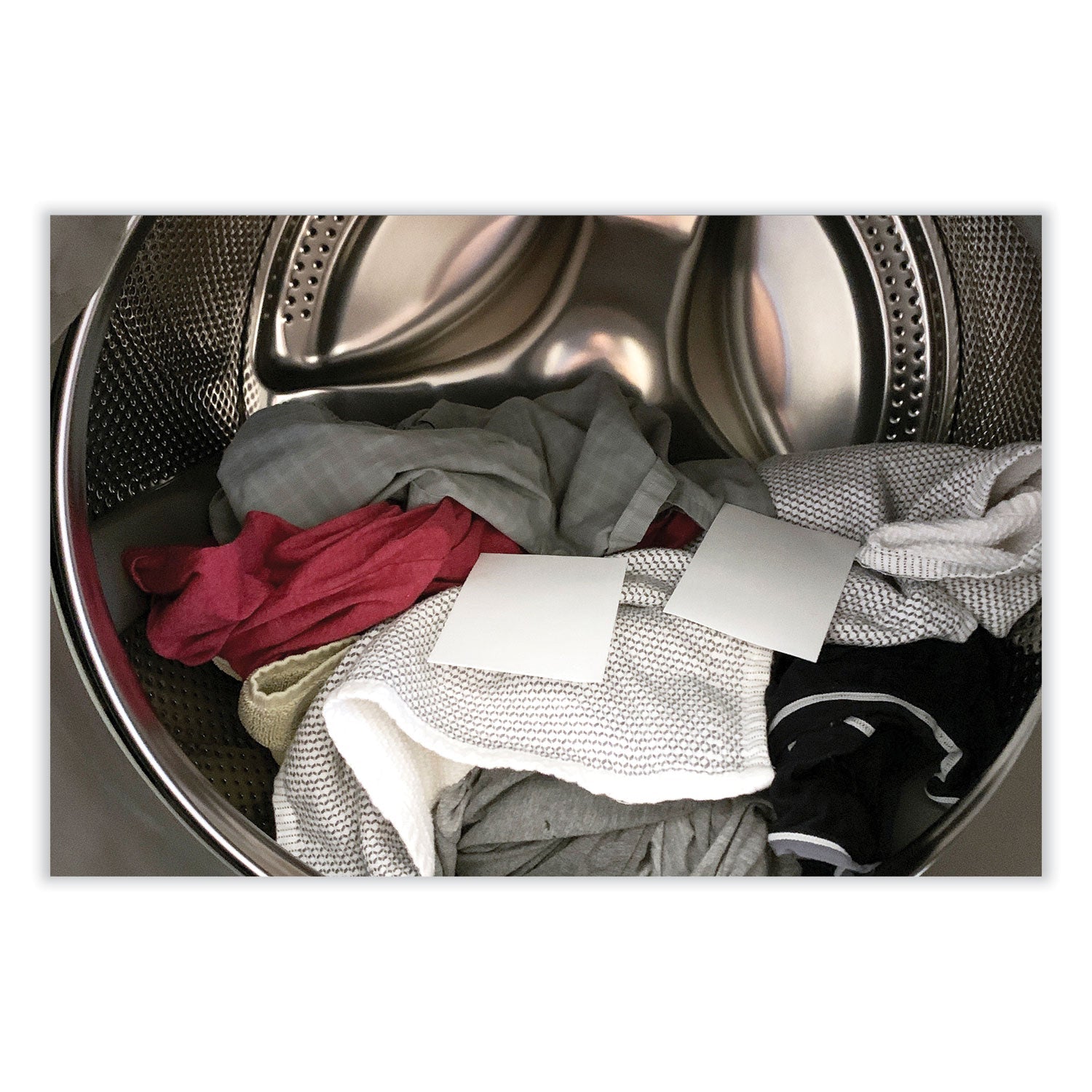 Laundry detergent sheets in a washing machine drum with folded clothes
