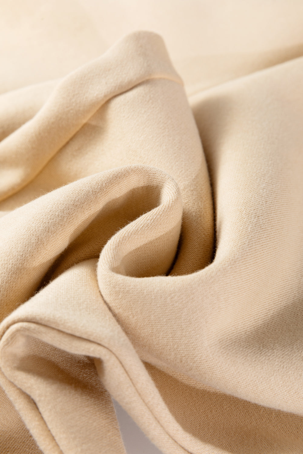 Oatmeal fabric close-up with soft drape folds
