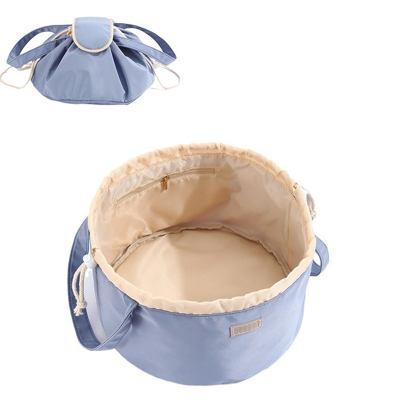 Light blue barrel drawstring makeup bag with top zipper and side cord handles