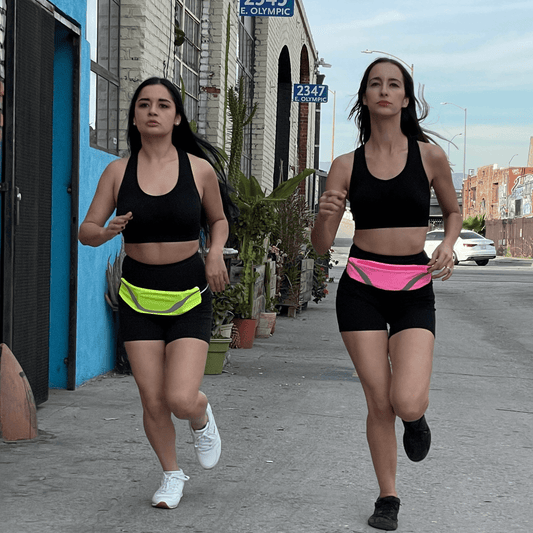 Water-resistant sport waist pack running belt with pink reflective stripe, worn at waist.