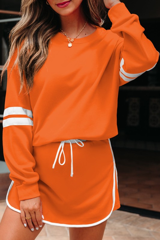 Orange pullover and mini skirt set with white sleeve stripe and drawstring waist.