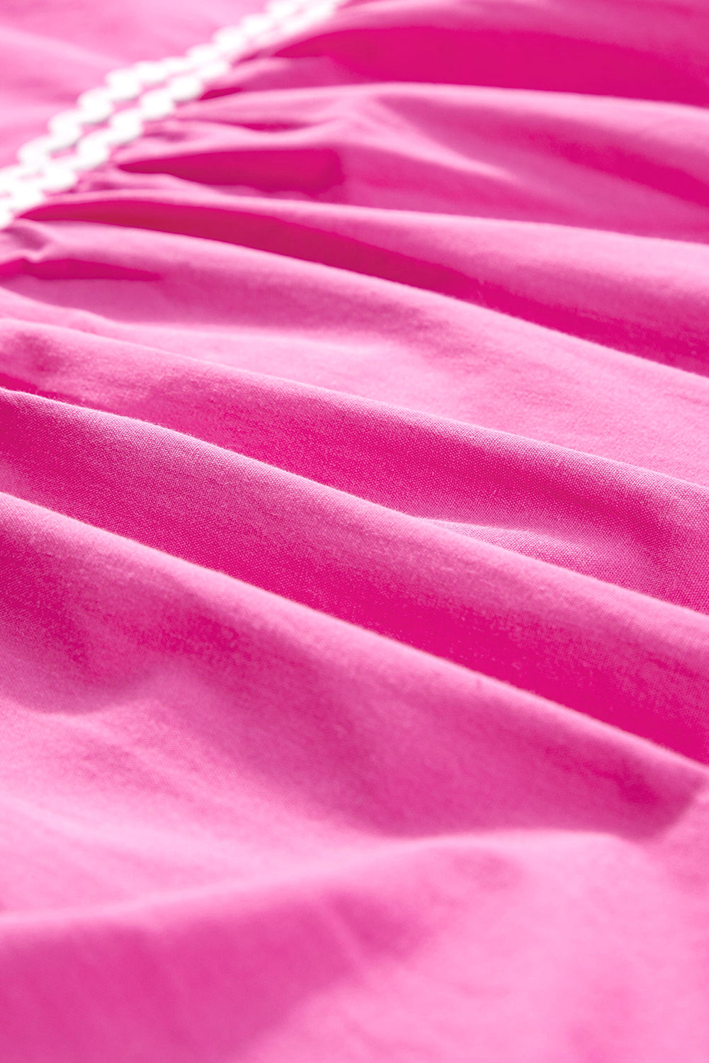 Close-up of strawberry pink fabric with soft pleated texture