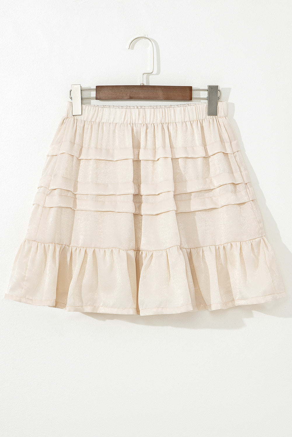 Beige tiered mini skirt with elastic waistband and layered ruffle panels