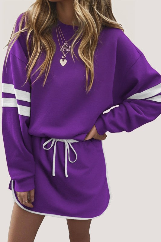 Purple varsity pullover with white striped sleeves and drawstring mini skirt