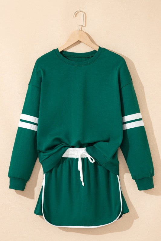Green crewneck pullover with white striped sleeves and drawstring mini skirt