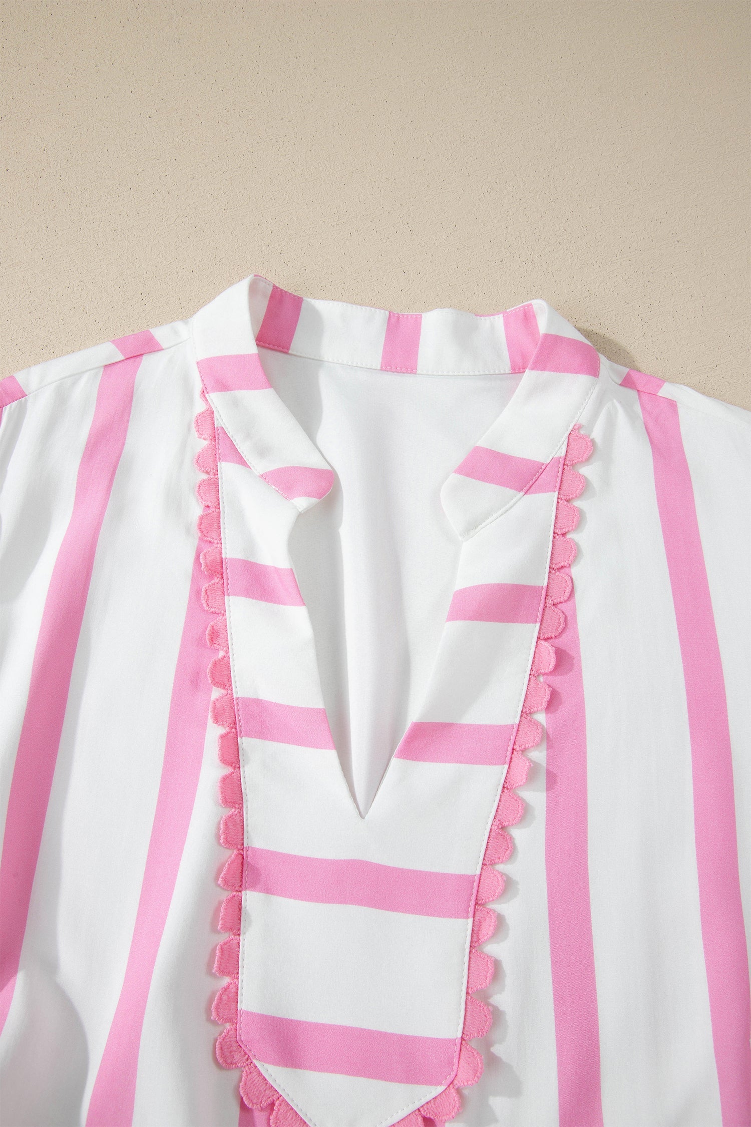 Close-up of V-neck pink-striped yoke with scalloped ruffle trim on the dress