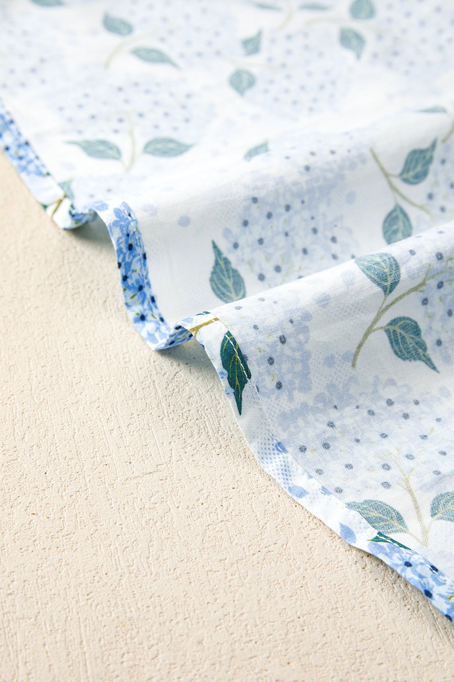 Sky blue dress hem with gathered ruffle and floral leaf-and-flower print