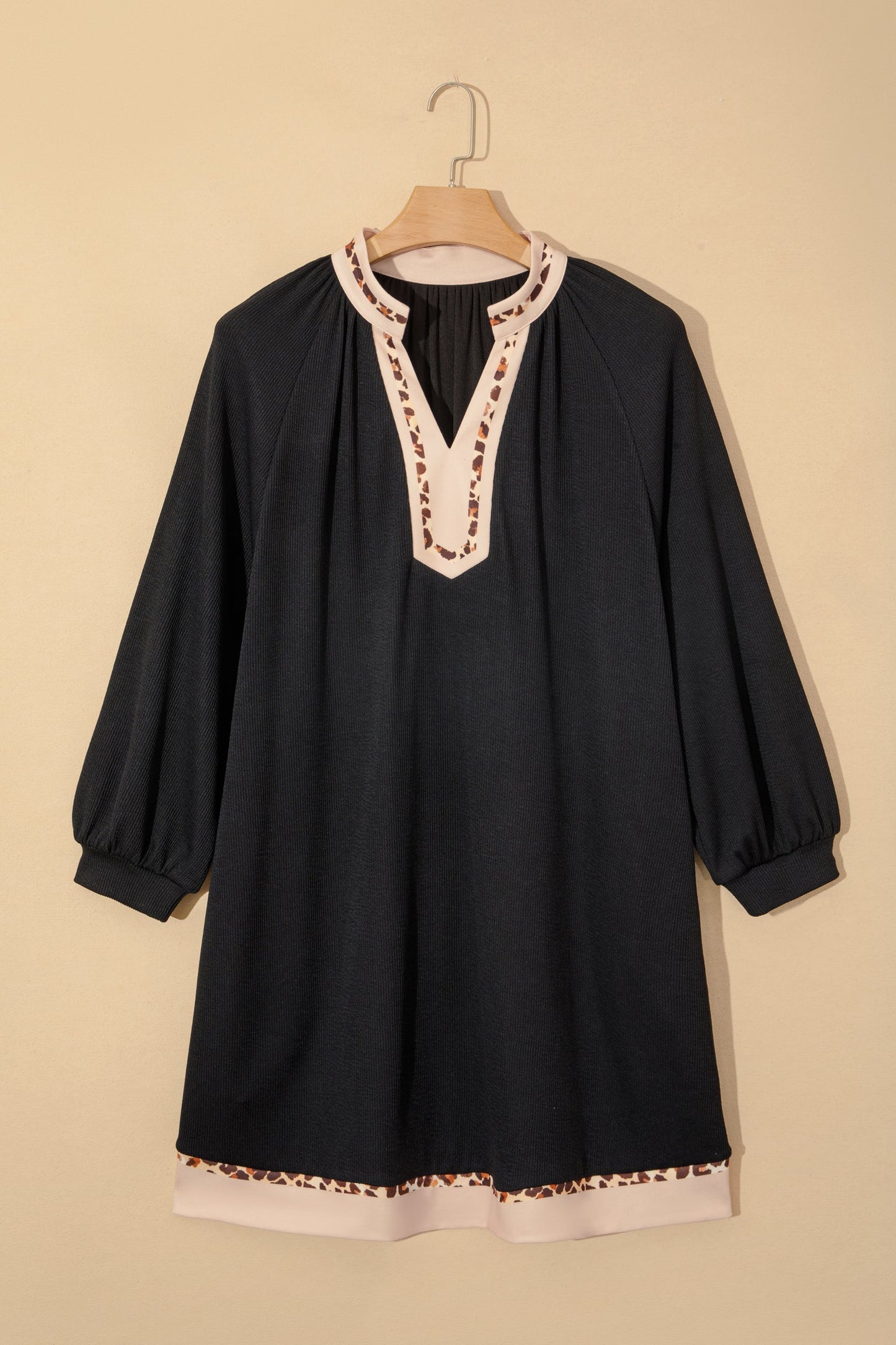 Black ribbed A-line dress on hanger, V-neck with leopard block trim and contrast hem