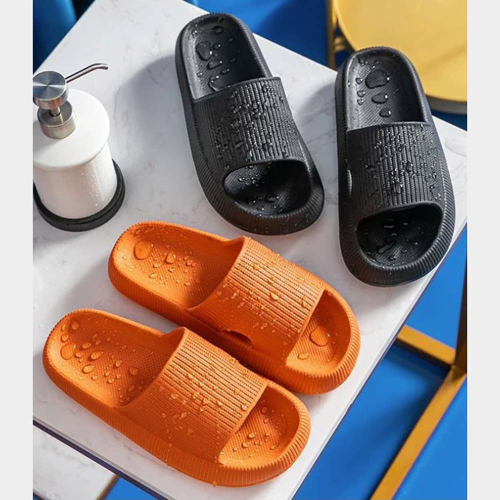 Black and orange slide sandals with wide straps and textured footbeds