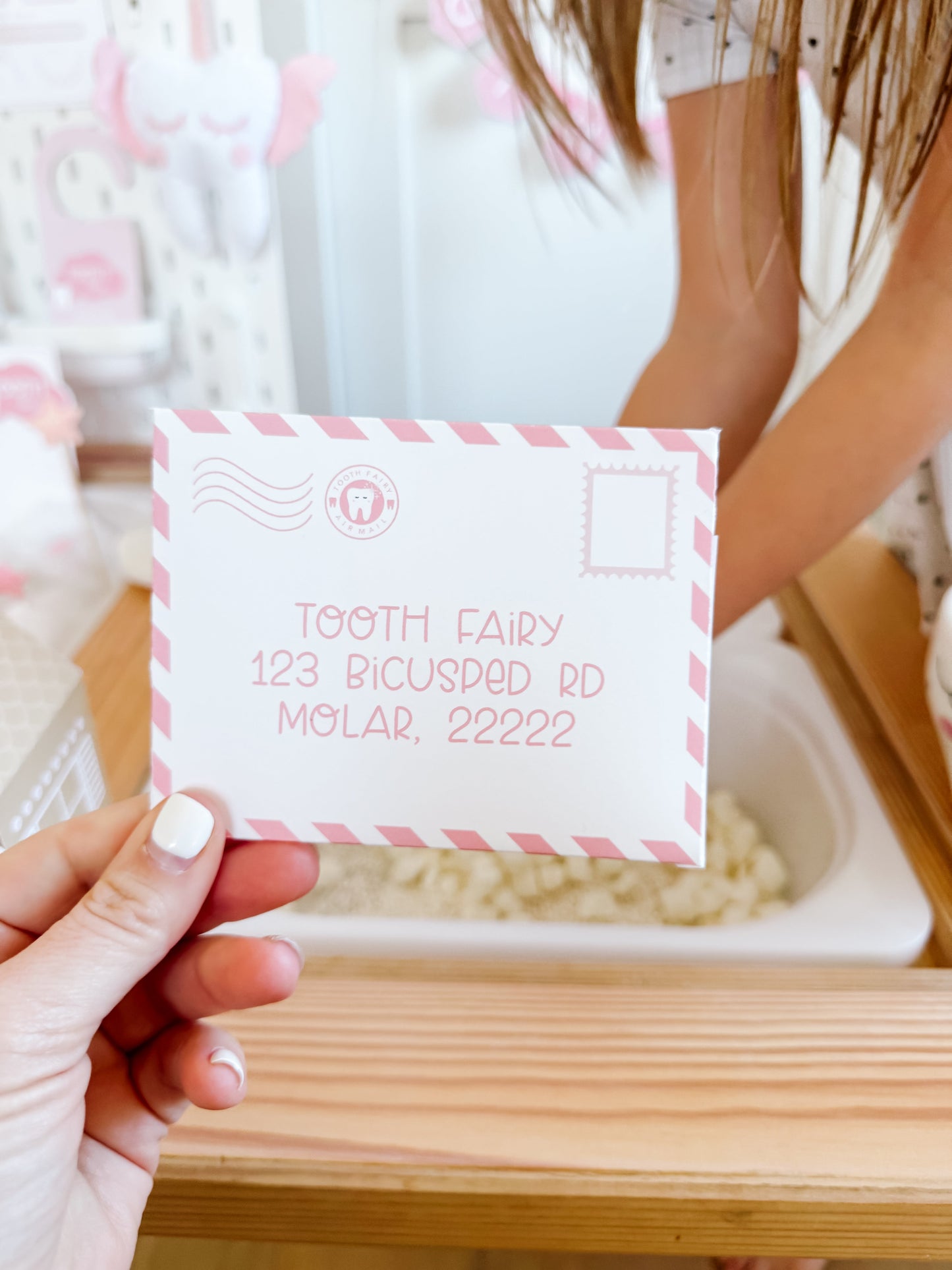 Tooth fairy note card with tooth icon and sample text, held over a tray
