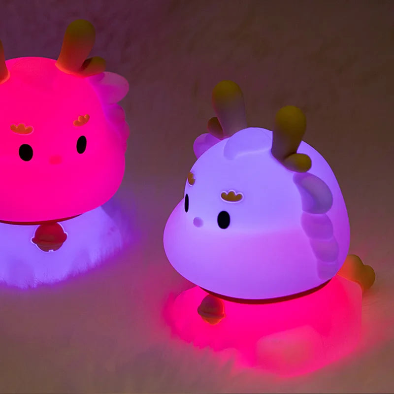 Two dragon-shaped LED night lights glowing pink and purple side by side