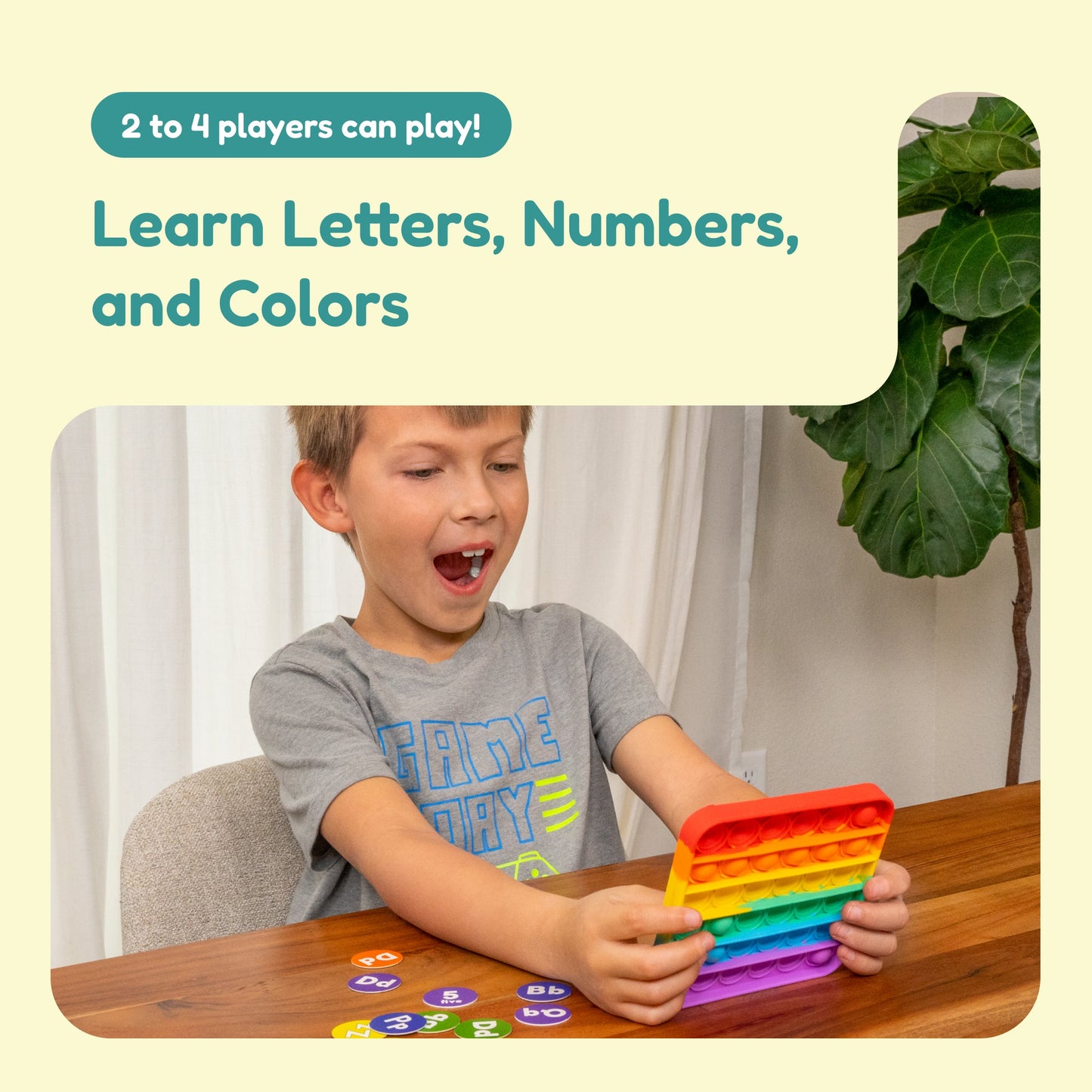 Young child holding a rainbow letter-number fidget mat with colorful number tokens