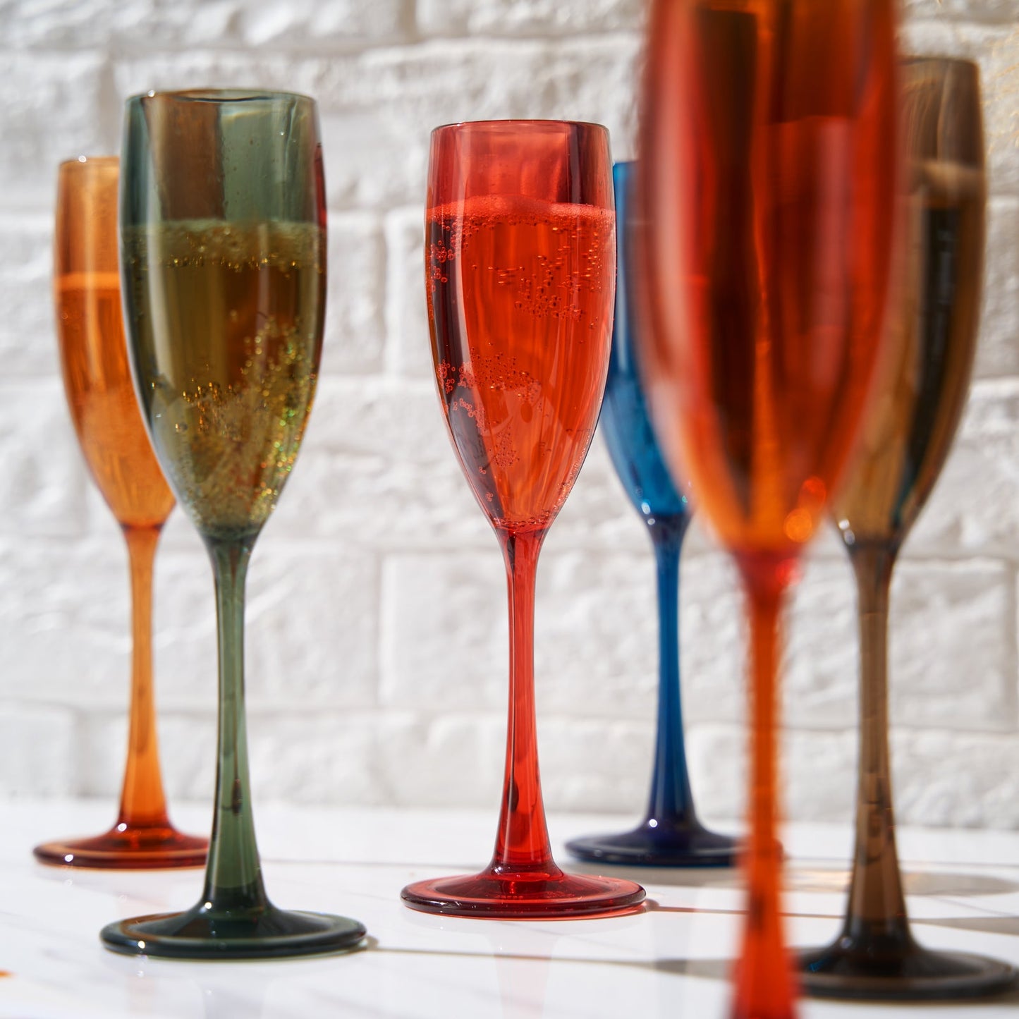Acrylic champagne flutes close-up, red green orange blue and tan bowls, set of 6.