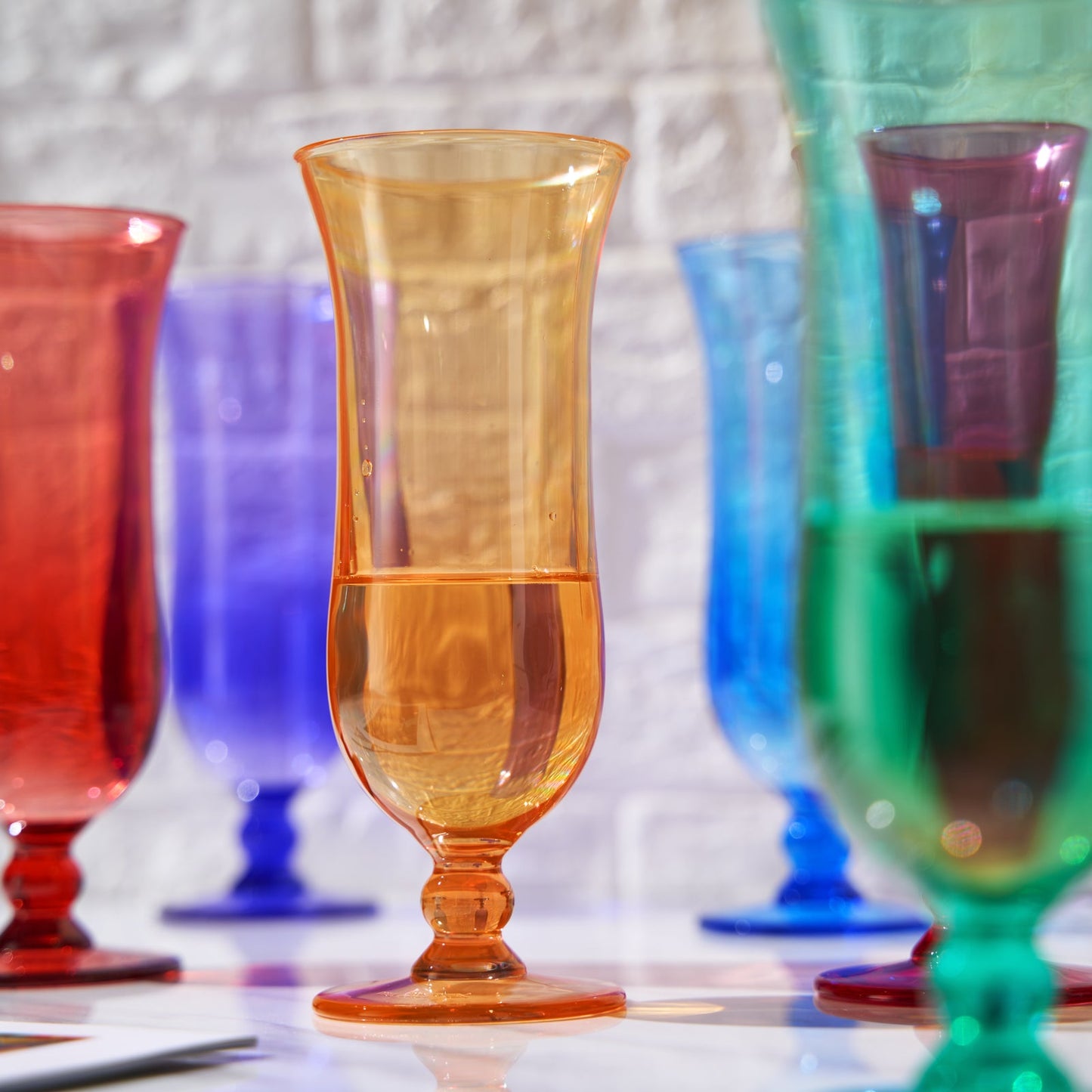 Amber acrylic hurricane cocktail glass with flared rim on a stem base