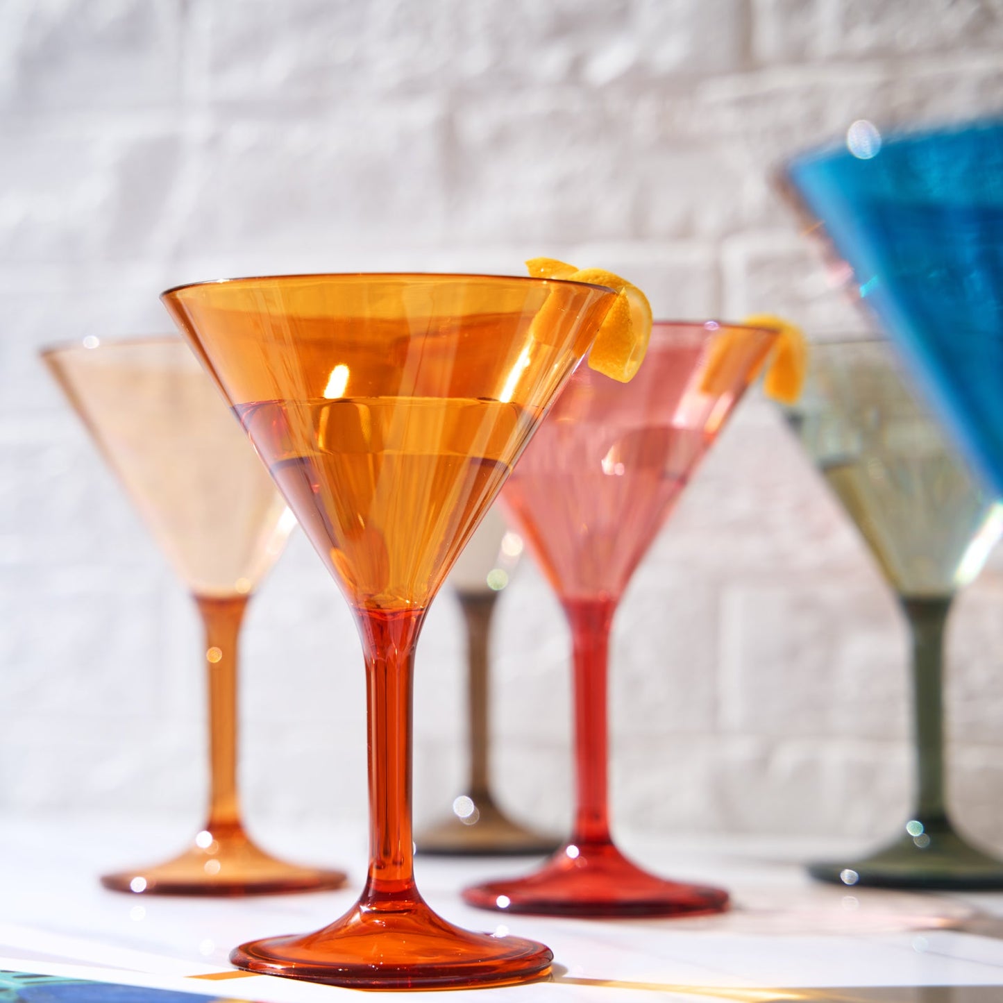 Orange acrylic martini cocktail glass with lemon twist, tulip shape and flared base