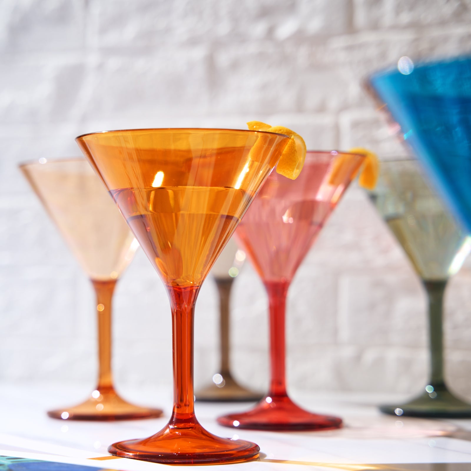 Orange acrylic martini cocktail glass with lemon twist, tulip shape and flared base