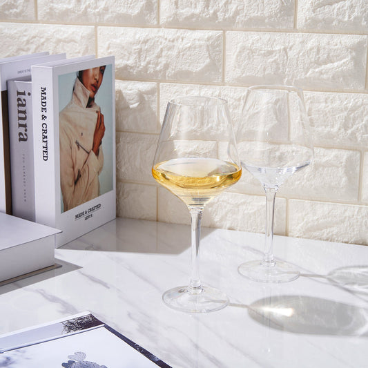 Stemmed wine glasses with clear bowls and pale yellow wine