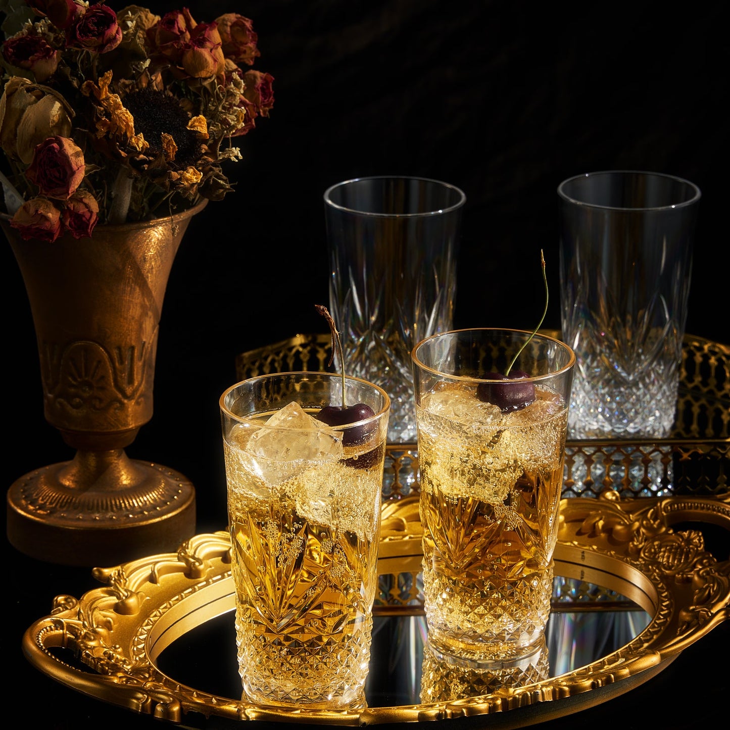 Acrylic highball glasses with faceted sides, several filled with amber drinks