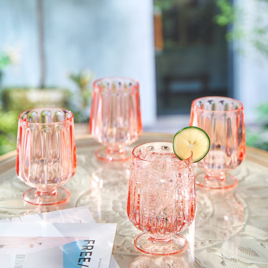 Rose-tinted stemmed acrylic wine goblet, ribbed sides and round base; with lime slice