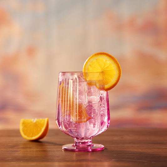 Pink tinted acrylic stemmed wine goblet with ribbed vertical sides and round base