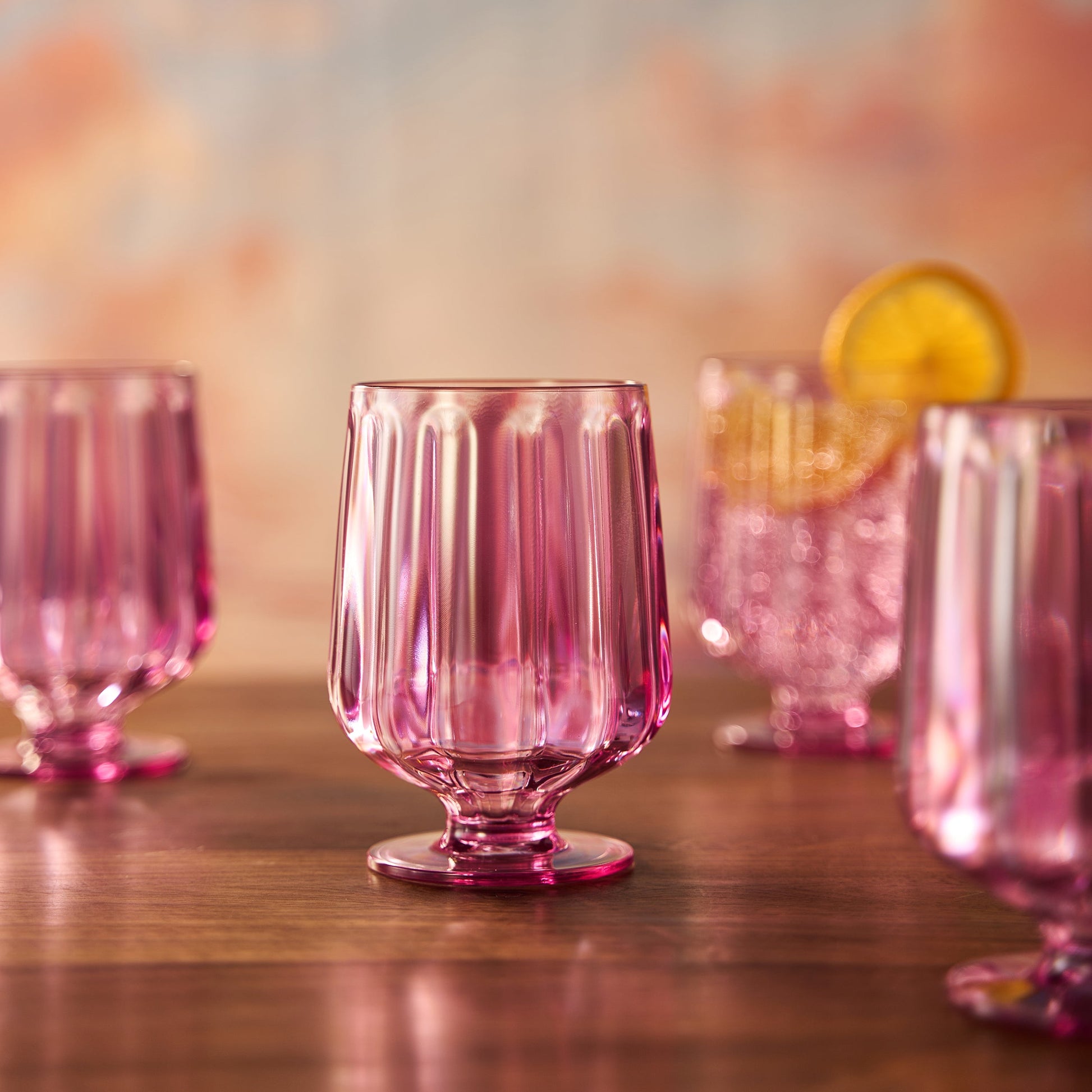 Pink tinted acrylic stemmed wine goblet, ribbed sides and sturdy stemmed foot