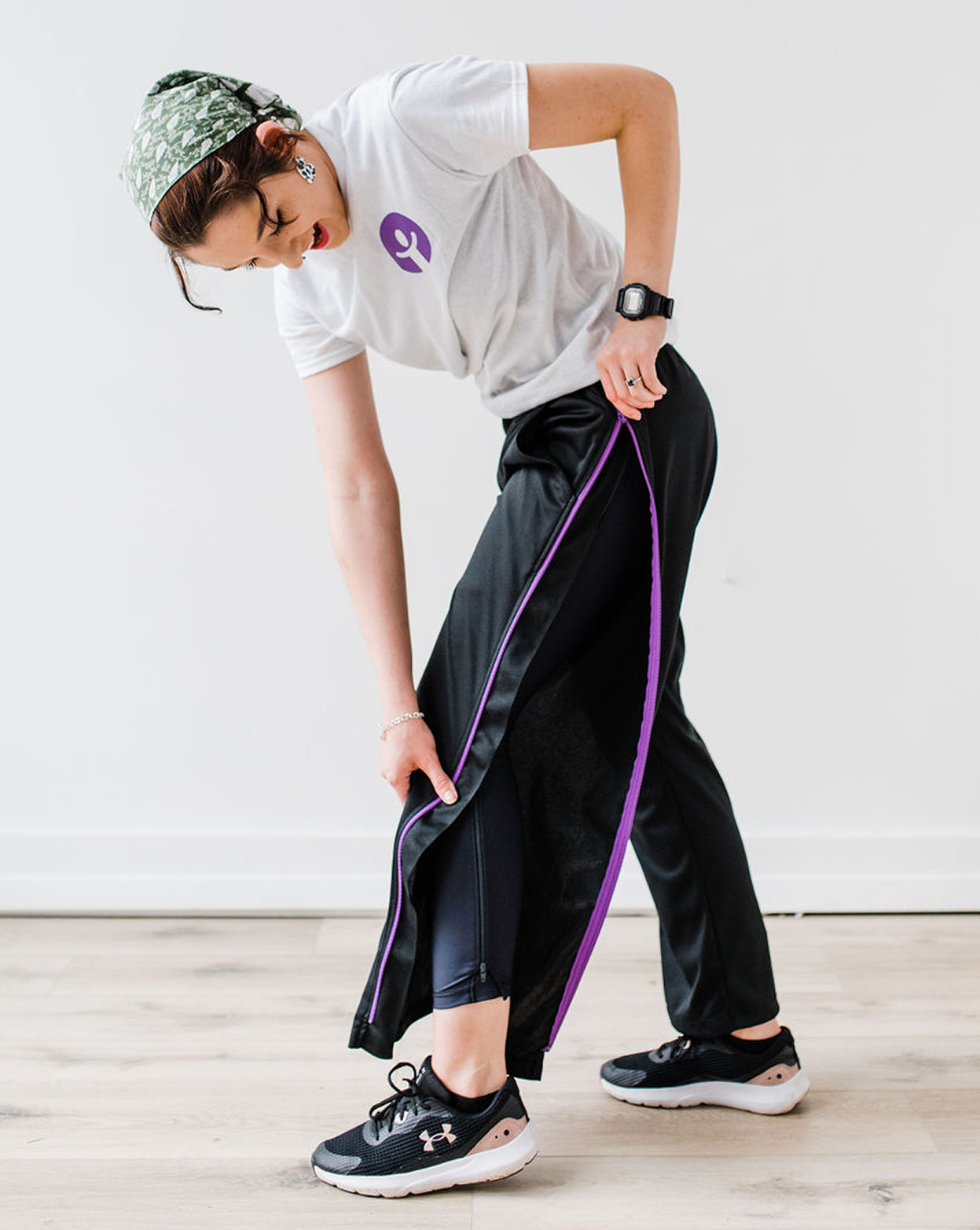 Person stretching with a purple resistance band in a home setting