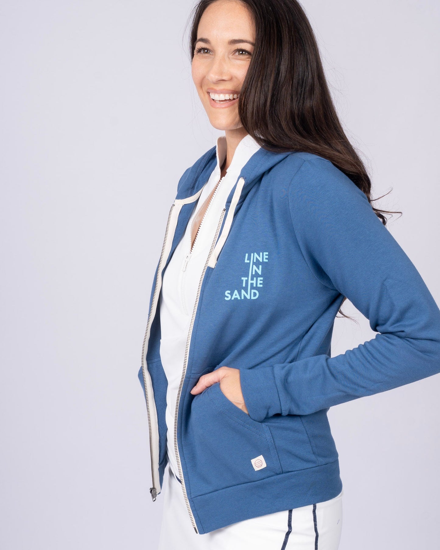 Blue zip hoodie with drawstring hood, front zipper, side pocket seam, and chest graphic.