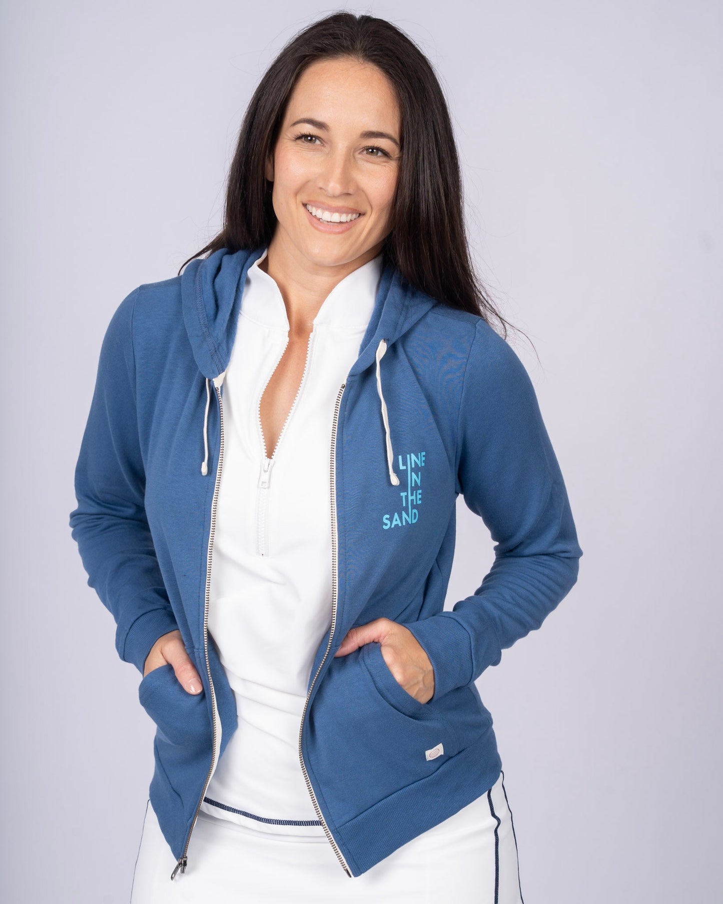Blue zip hoodie with drawstring hood, full front zipper, and “LINE IN THE SAND” chest print.
