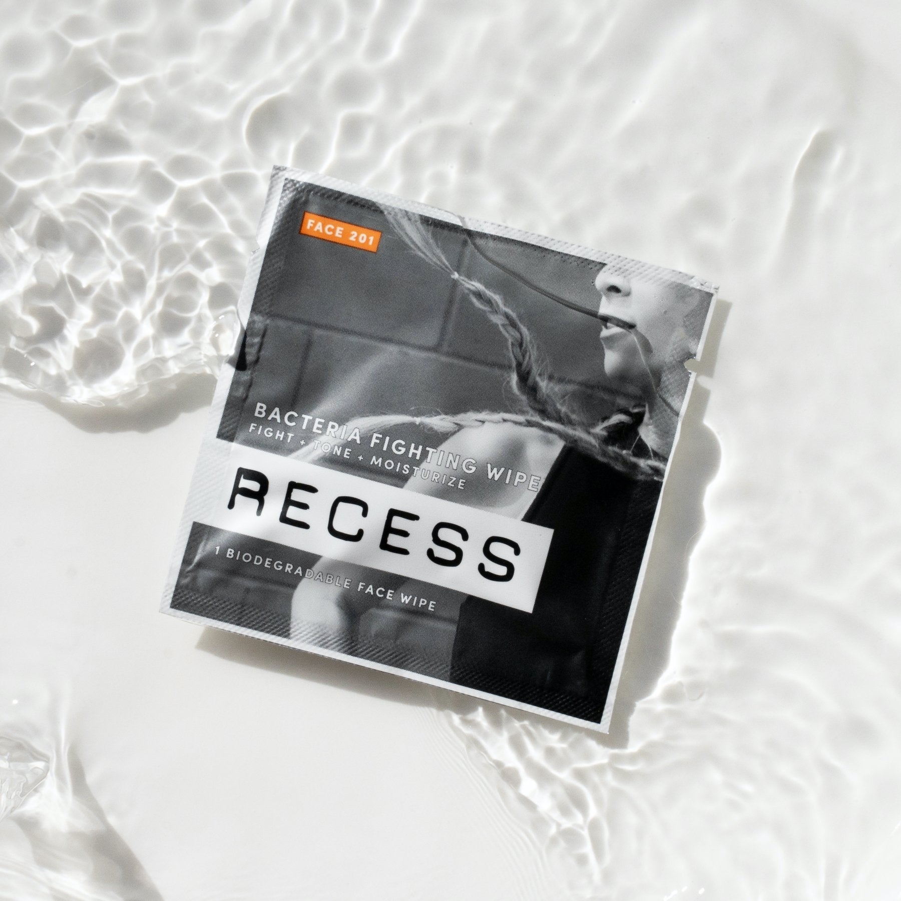 Biodegradable face wipe pouch with RECESS branding and FACE 201 orange label