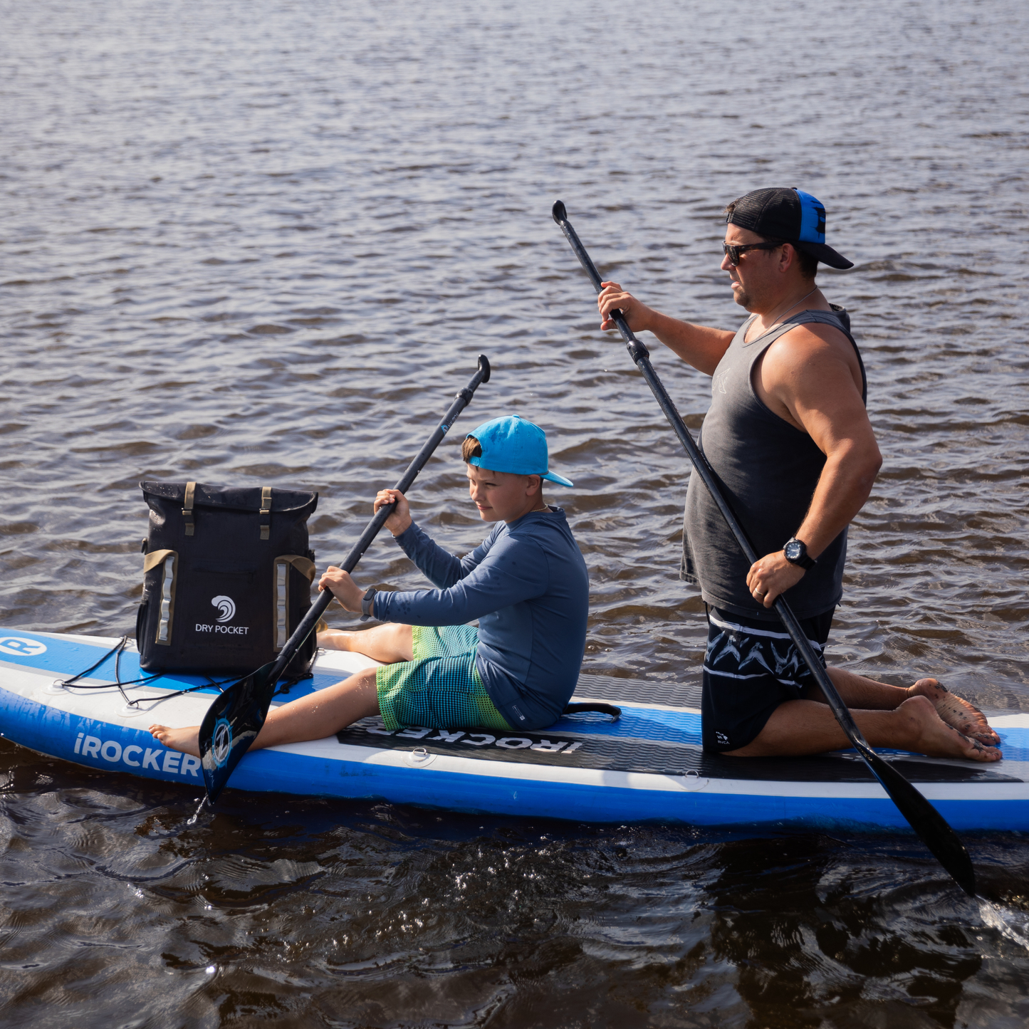 Waterproof floating tote cooler in dark gray on inflatable boat, with white straps