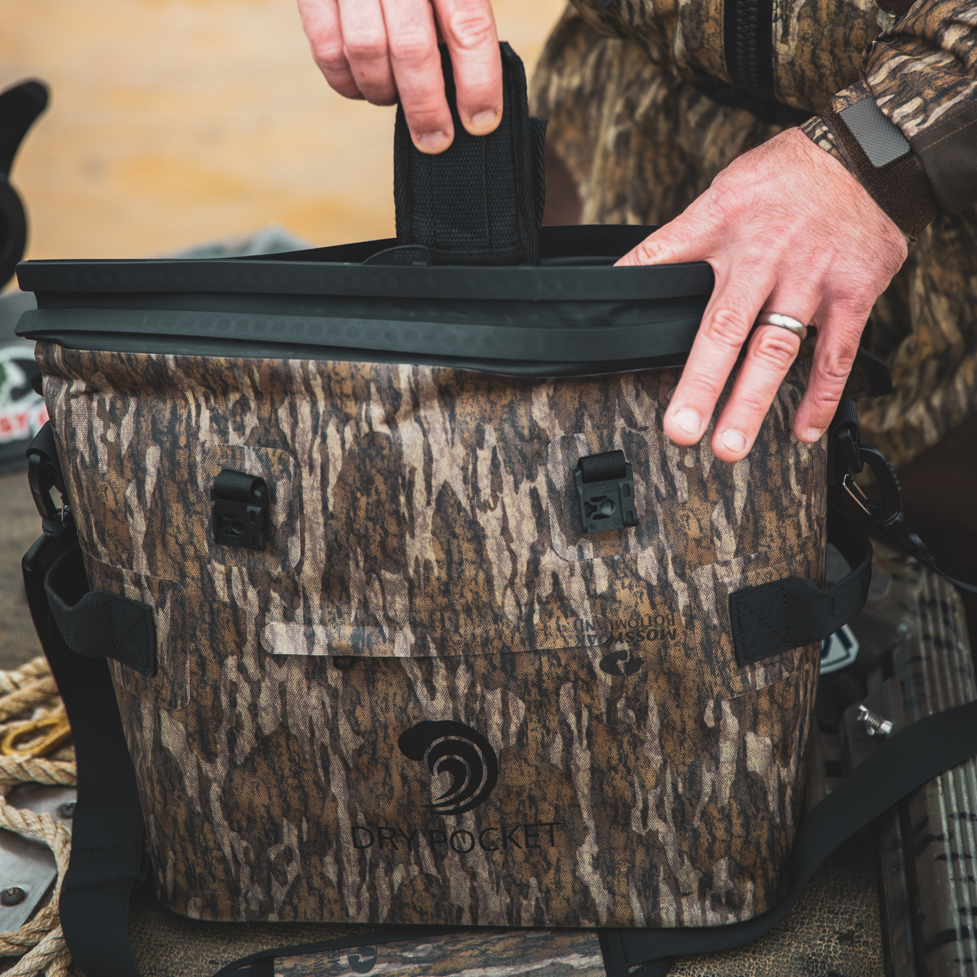 Waterproof floating cooler bag in Mossy Oak camo with top lid and front Dry Pocket logo