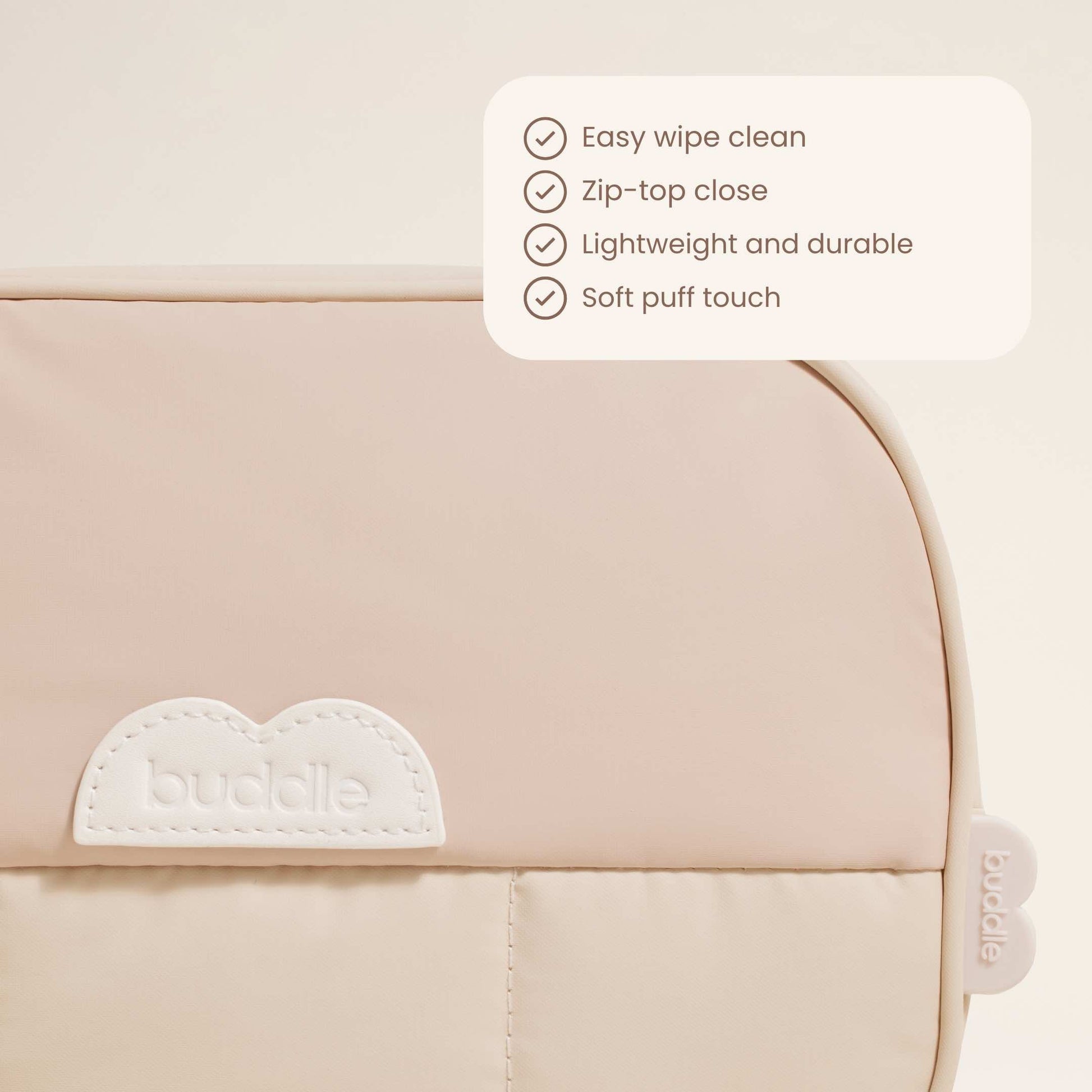 Beige diaper changing bag front panel with embossed buddle logo patch