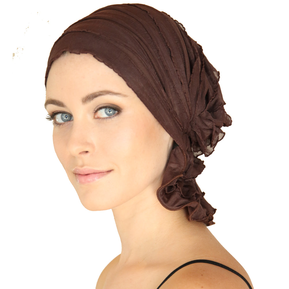 Brown ruched chemo beanie with braided wrap and side flower detail, angled front