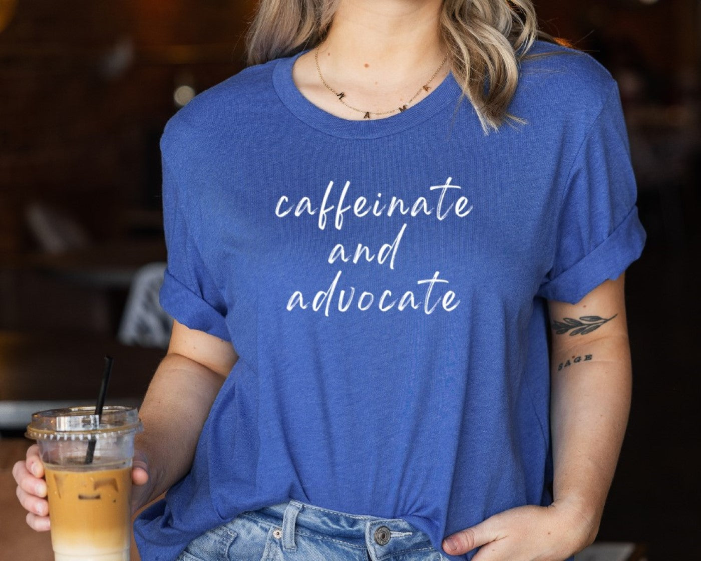 Blue crew-neck T-shirt with 'caffeinate and advocate' script print
