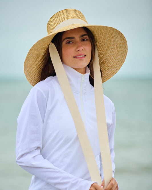 Capri sun hat with straw wide brim, white headband, and two long chin ties.