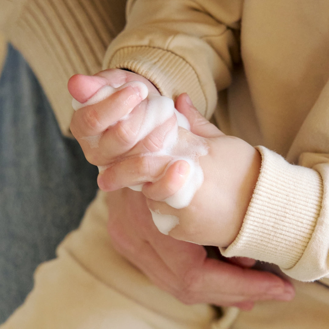 Foam cleanser lather being rubbed into a child’s hands