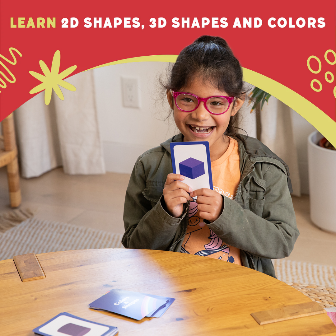 Child holding a blue-framed shape card during a 2D and 3D shapes activity