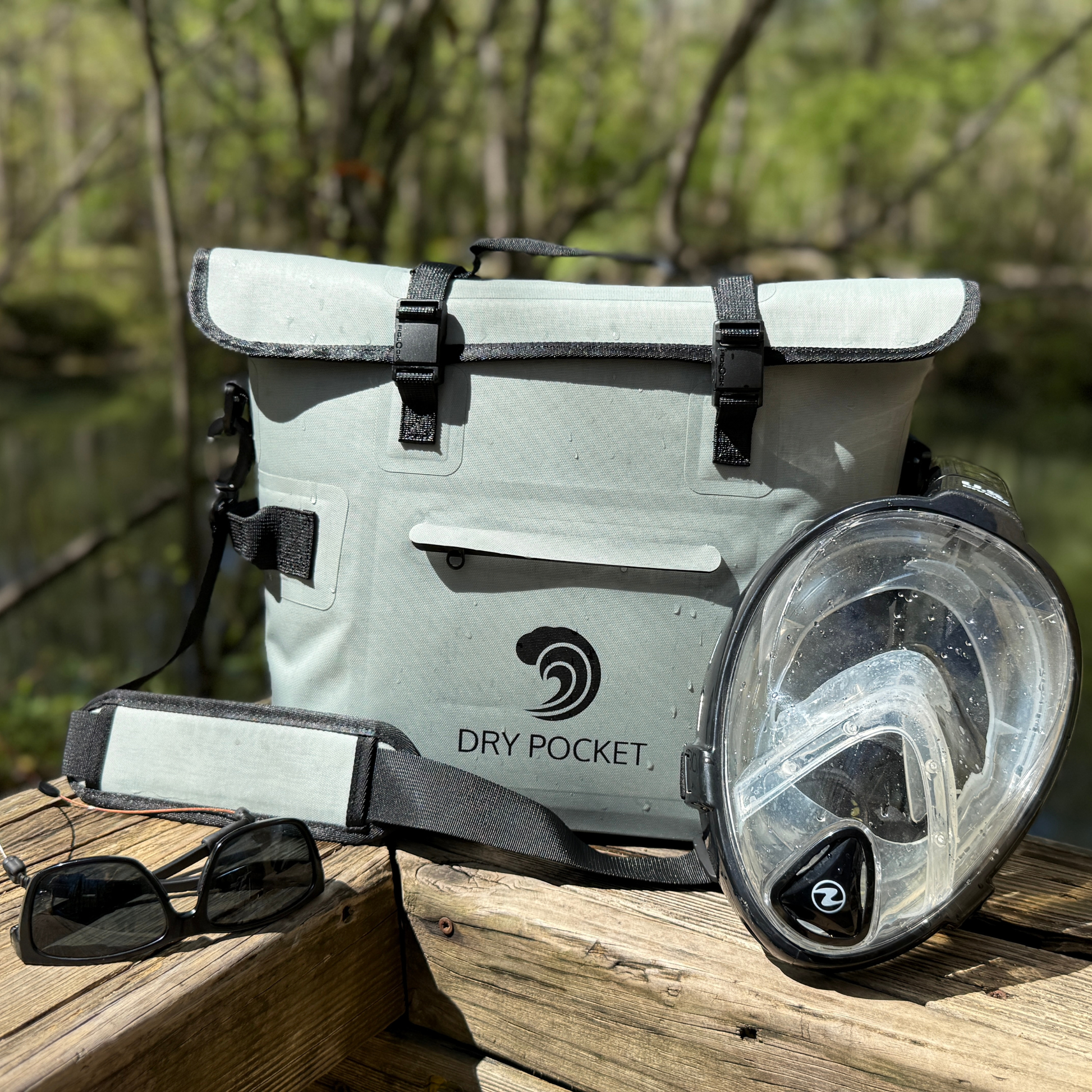 Waterproof floating cooler bag on dock, light gray body with DRY POCKET logo and mask