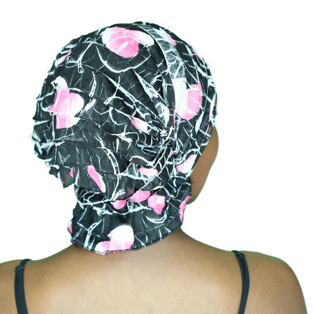 Black chemo beanie with pink floral and white web pattern, back side draped ruffles