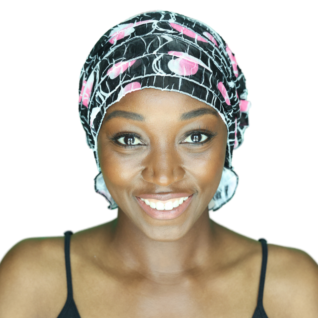 Black chemo beanie with pink floral and white web pattern, ruched cap on head