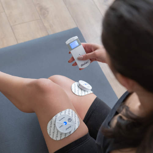 Therapeutic wearable system electrode pad on leg with wireless controller held in hand