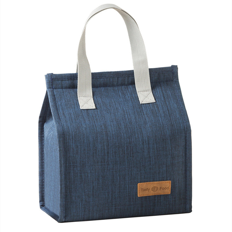 Blue insulated lunch bag with light gray top handles and tan logo label patch