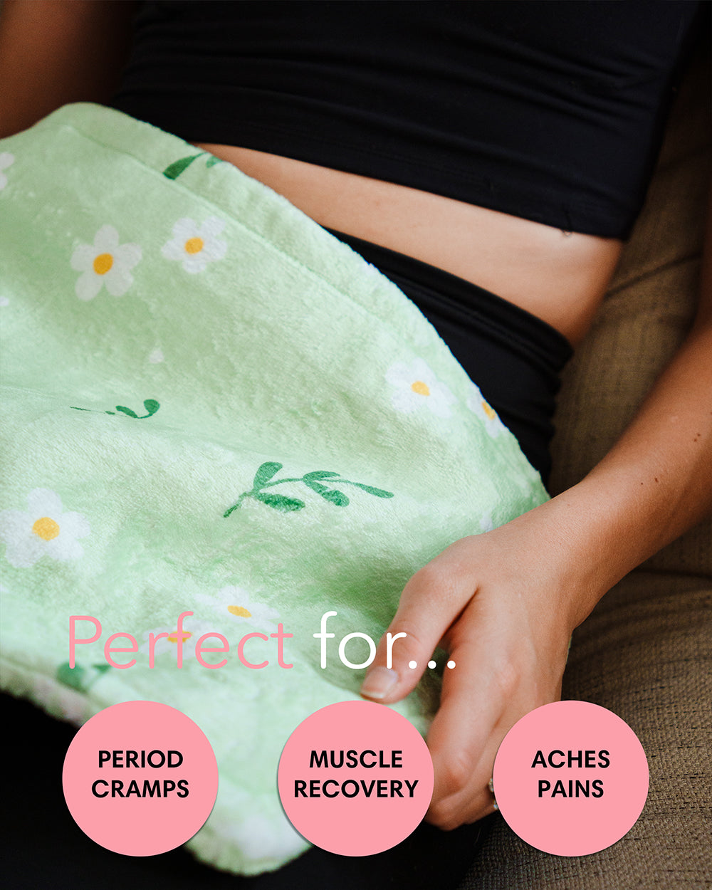 Mint green floral heating pad resting on legs, white daisies and green foliage print
