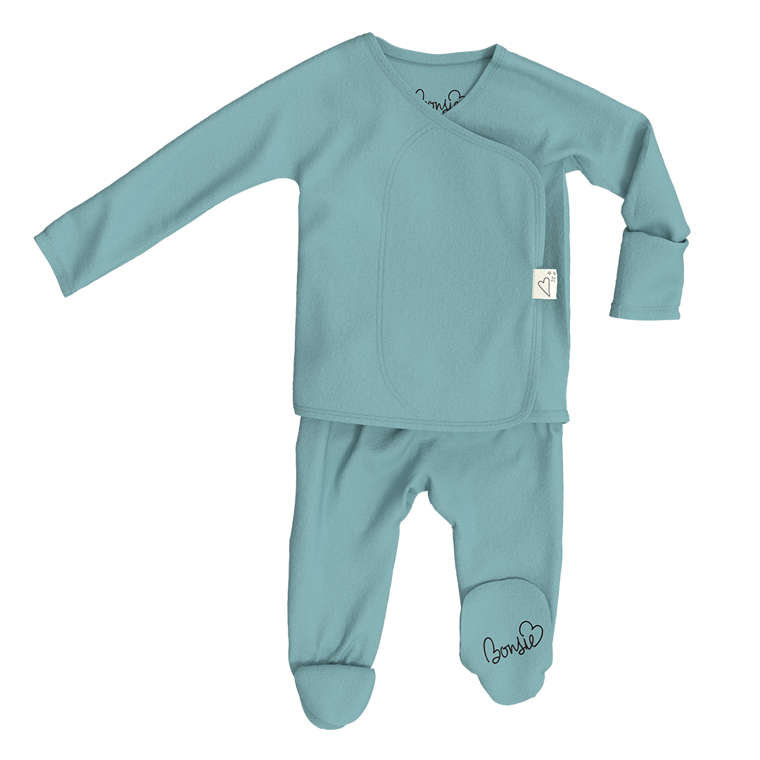 Teal baby outfit with long-sleeve top and footed pants on a white background