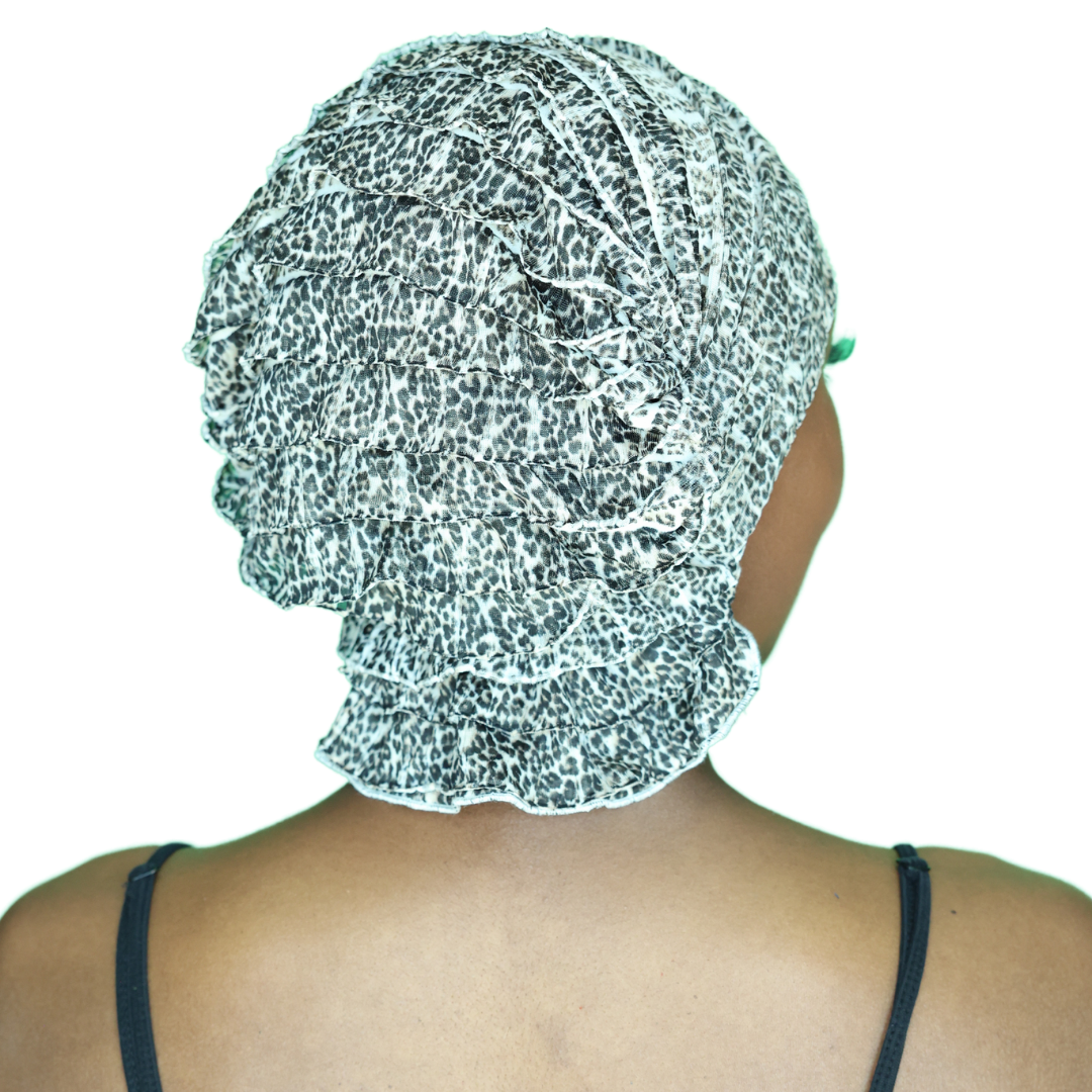Leopard-print head wrap, profile view with gathered ruffle and speckled pattern